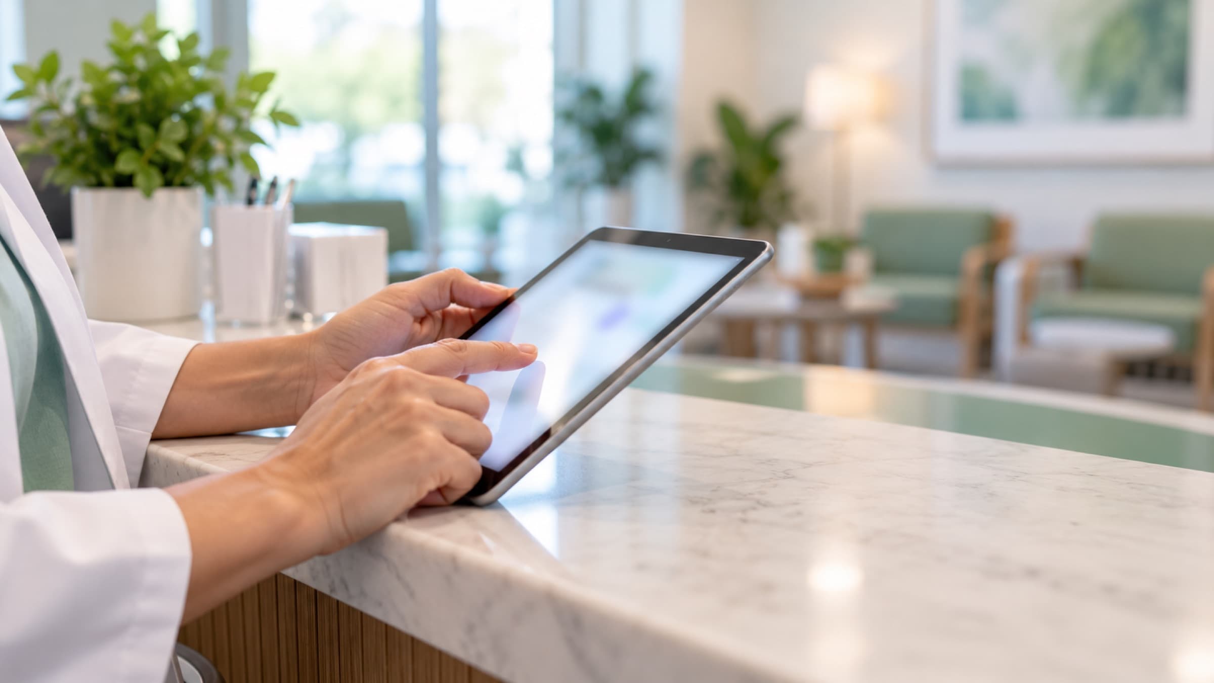 受付でタブレットを操作する手元(イメージ)